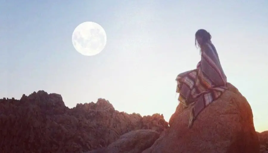 Woman on rock in full Moon