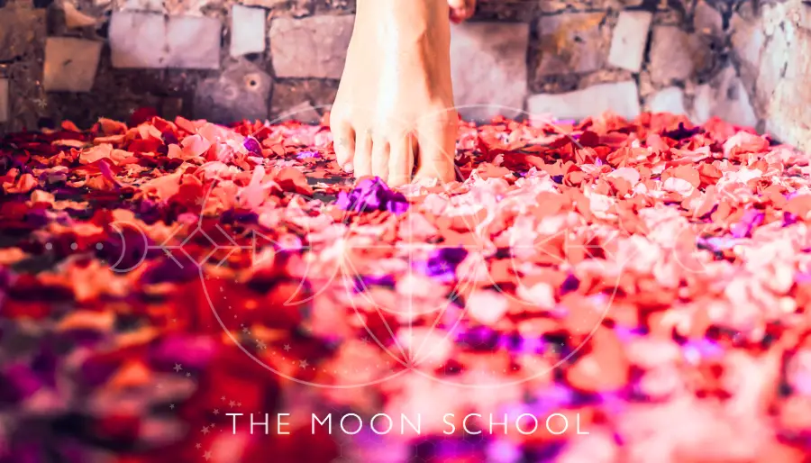Woman stepping into a ritual moon bath with rose petals