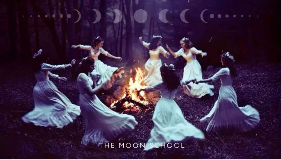Sisterhood of spiritual witchy women dancing around a full moon fire