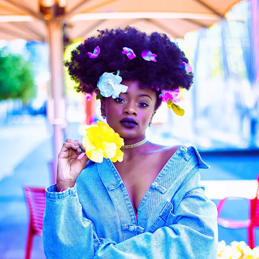 woman of colour with flowers in her hair embodying the diva archetype