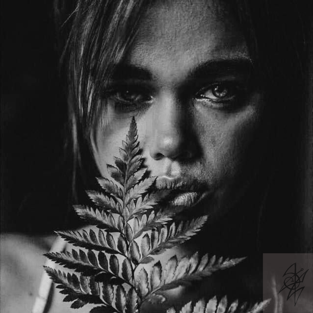 black and white image of scorpio Moon women with fern over her face