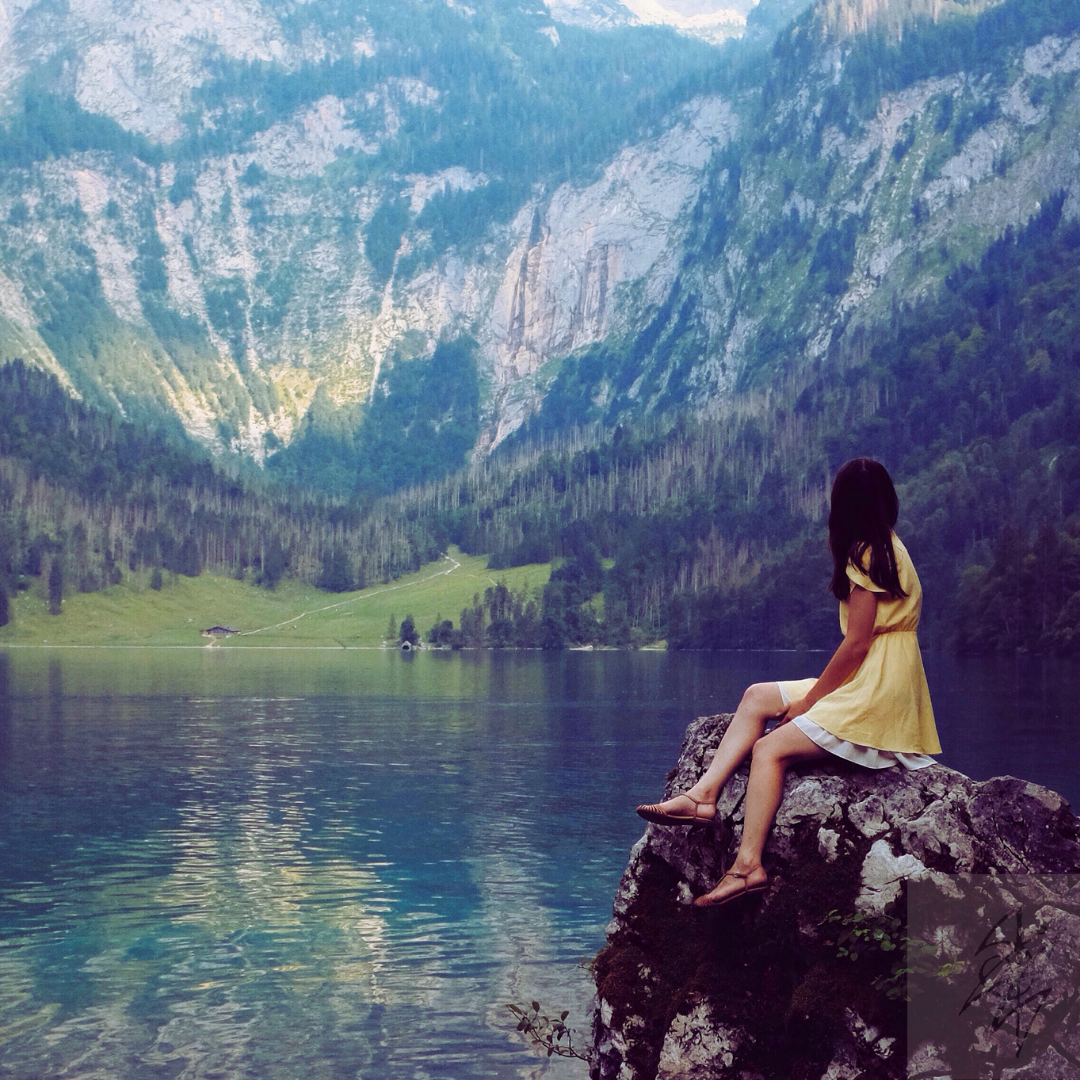 physical appearance of a Sagittarius Moon woman in a dress sitting by a lake