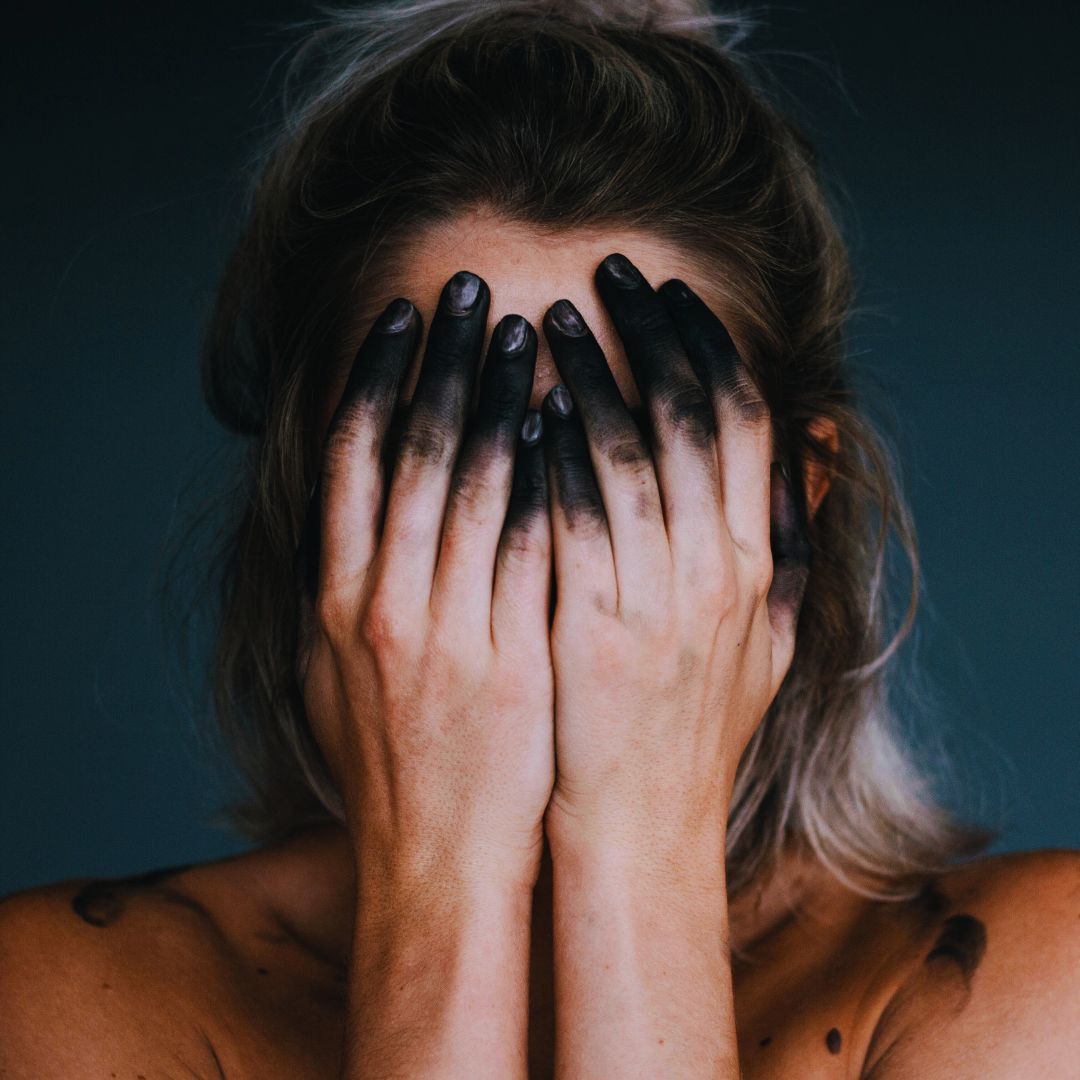 Dark feminine woman with black paint on her fingers