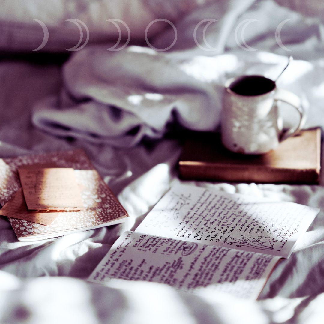 journal on a bed with coffee in morning sunlight