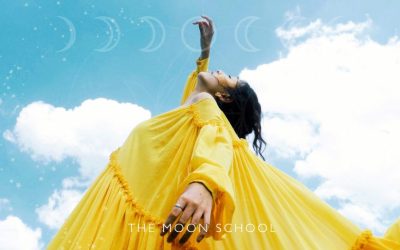 Woman with yellow dress reaching up into the sky in a letting go ritual