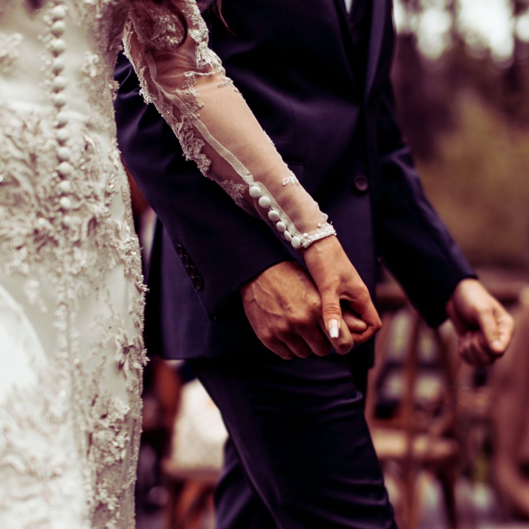 couple holding hands on a wedding day with energetic cord