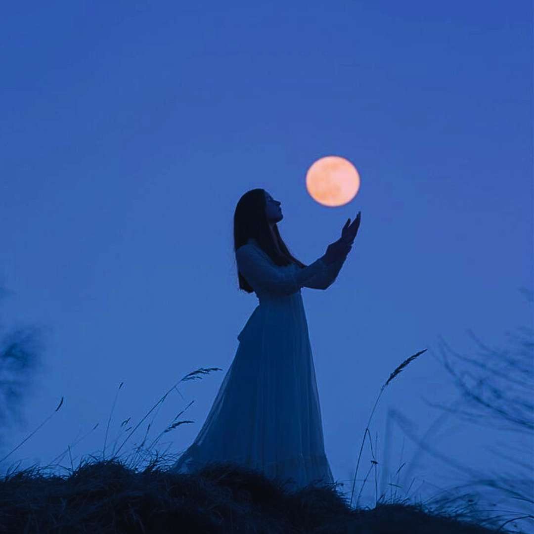Witchy woman holding a full Moon