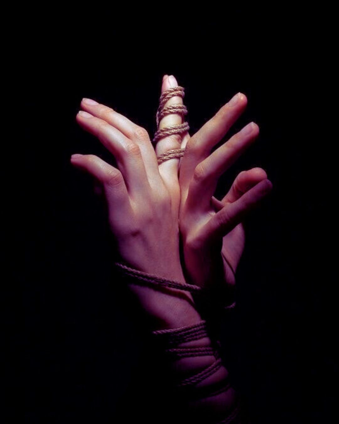 Artistic picture of cords tying two hands together