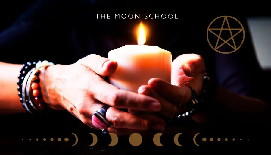 witchy woman holding a candle in her hands explaining candle colours in witchcraft