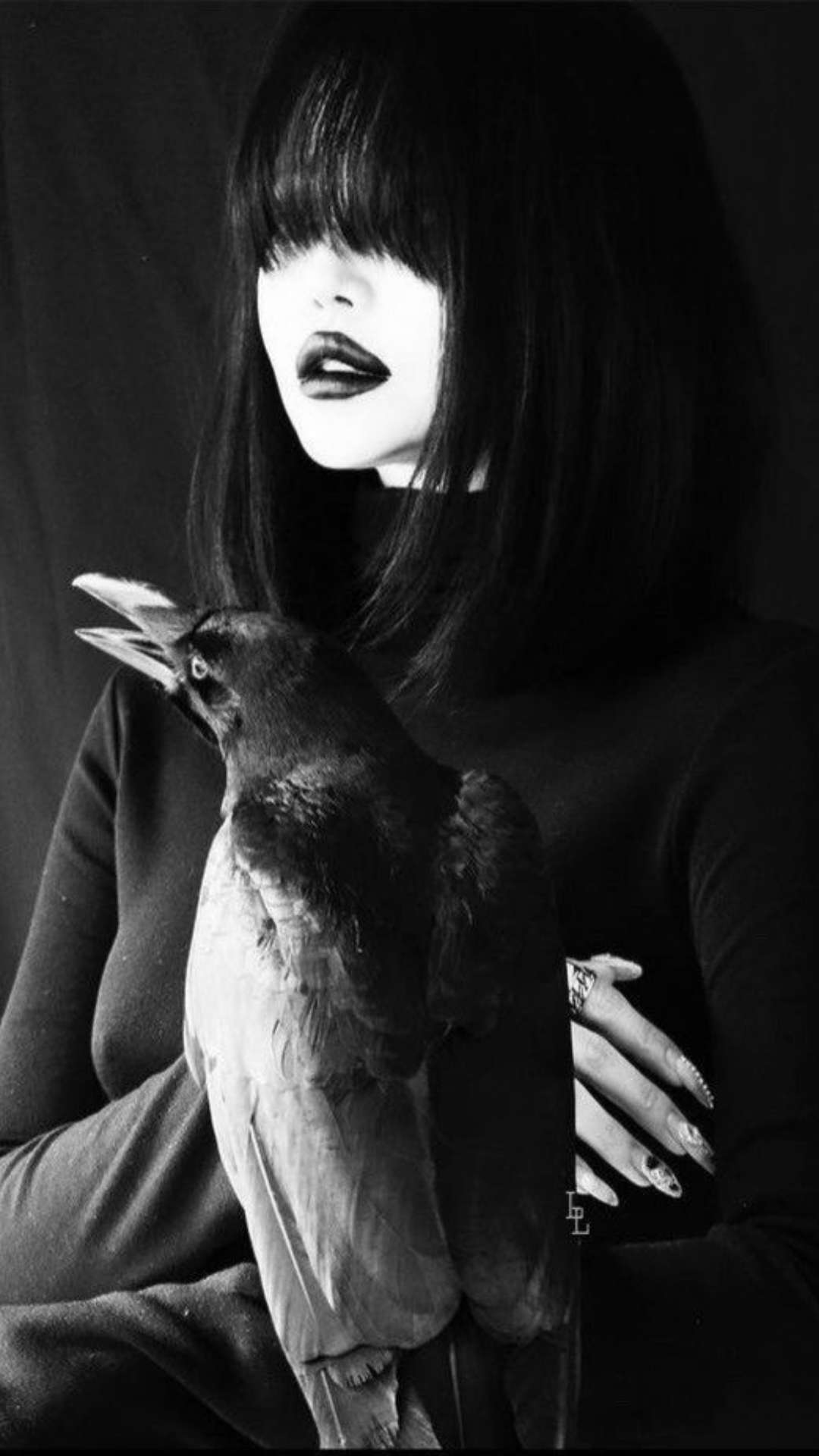 Dark femme woman with a gothic witch aesthetic and a crow