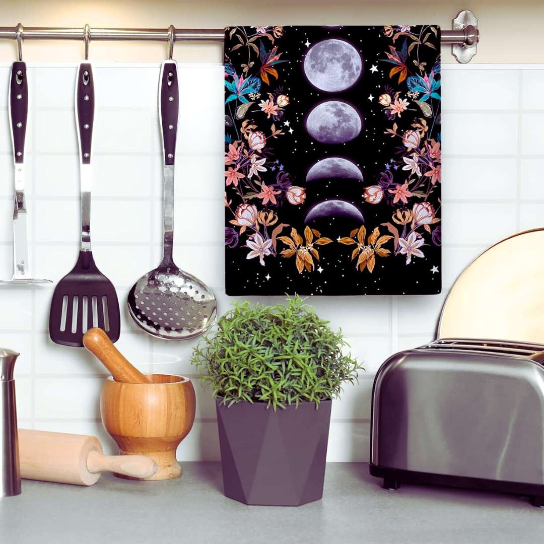 Black tea towels with lunar phase print hanging in a kitchen, ideal witchy gift idea 