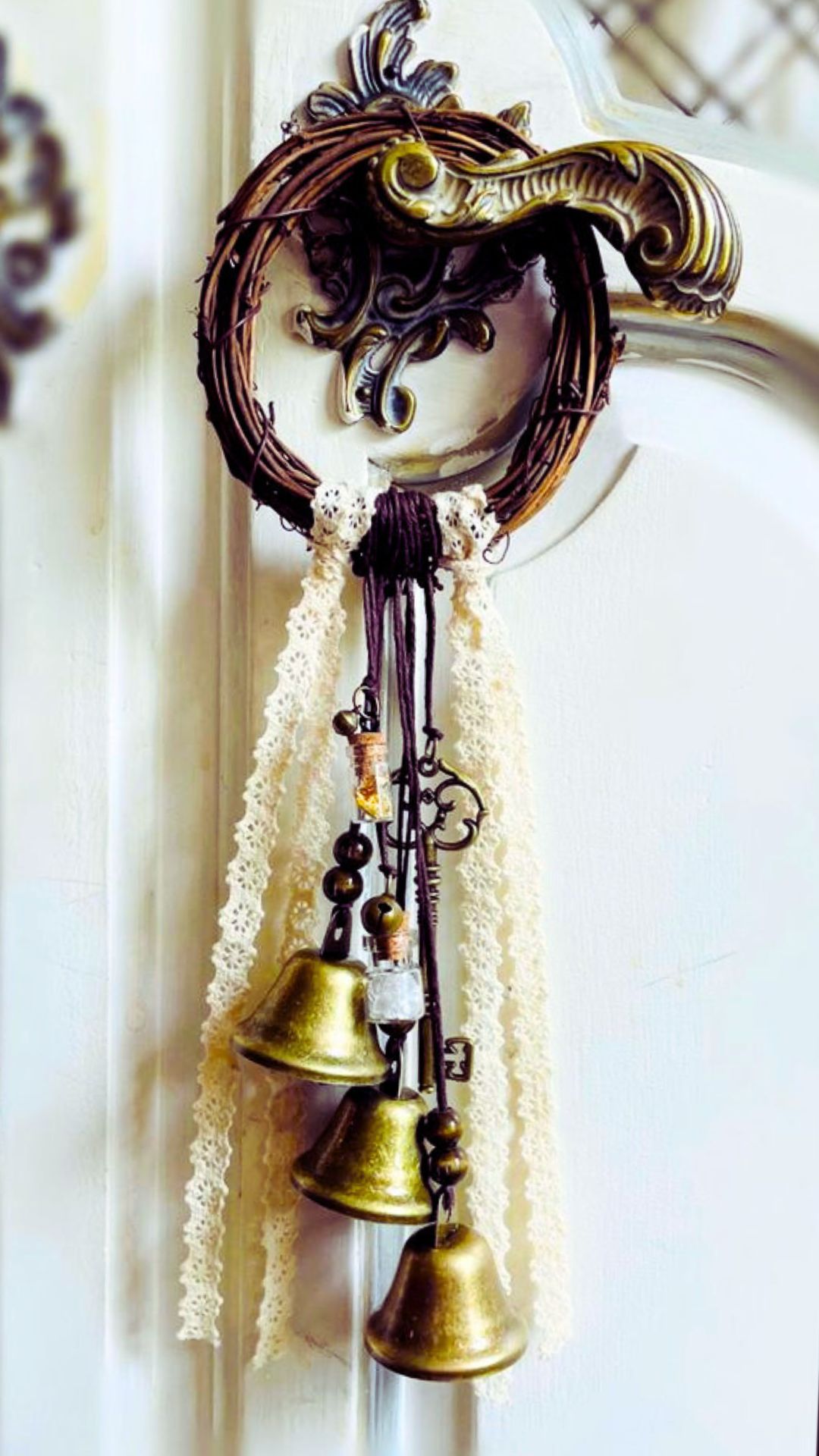 Small decorative witch bells wreath with key charm hanging on a door handle