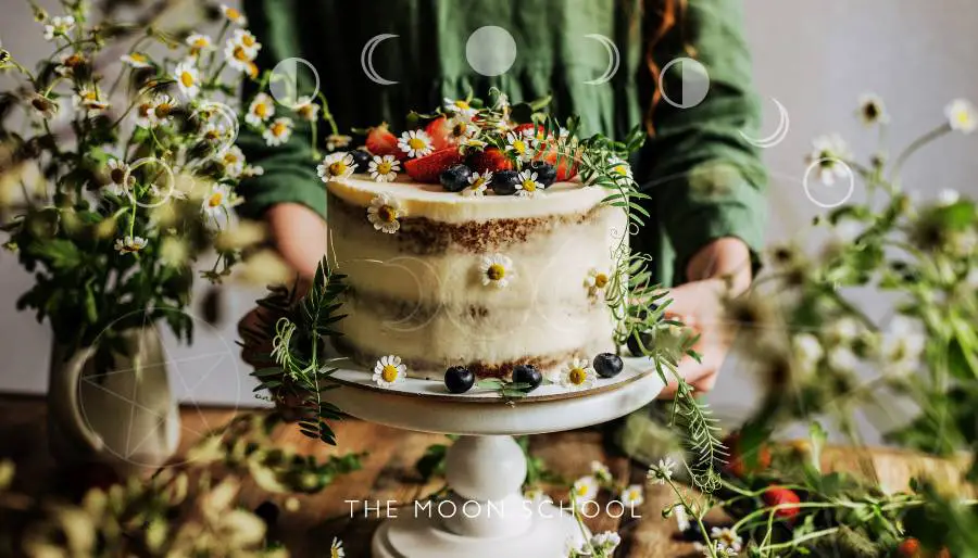 Beautiful full moon cake being decorated with flowers, fruit, natural decorations, placed on a cake stand