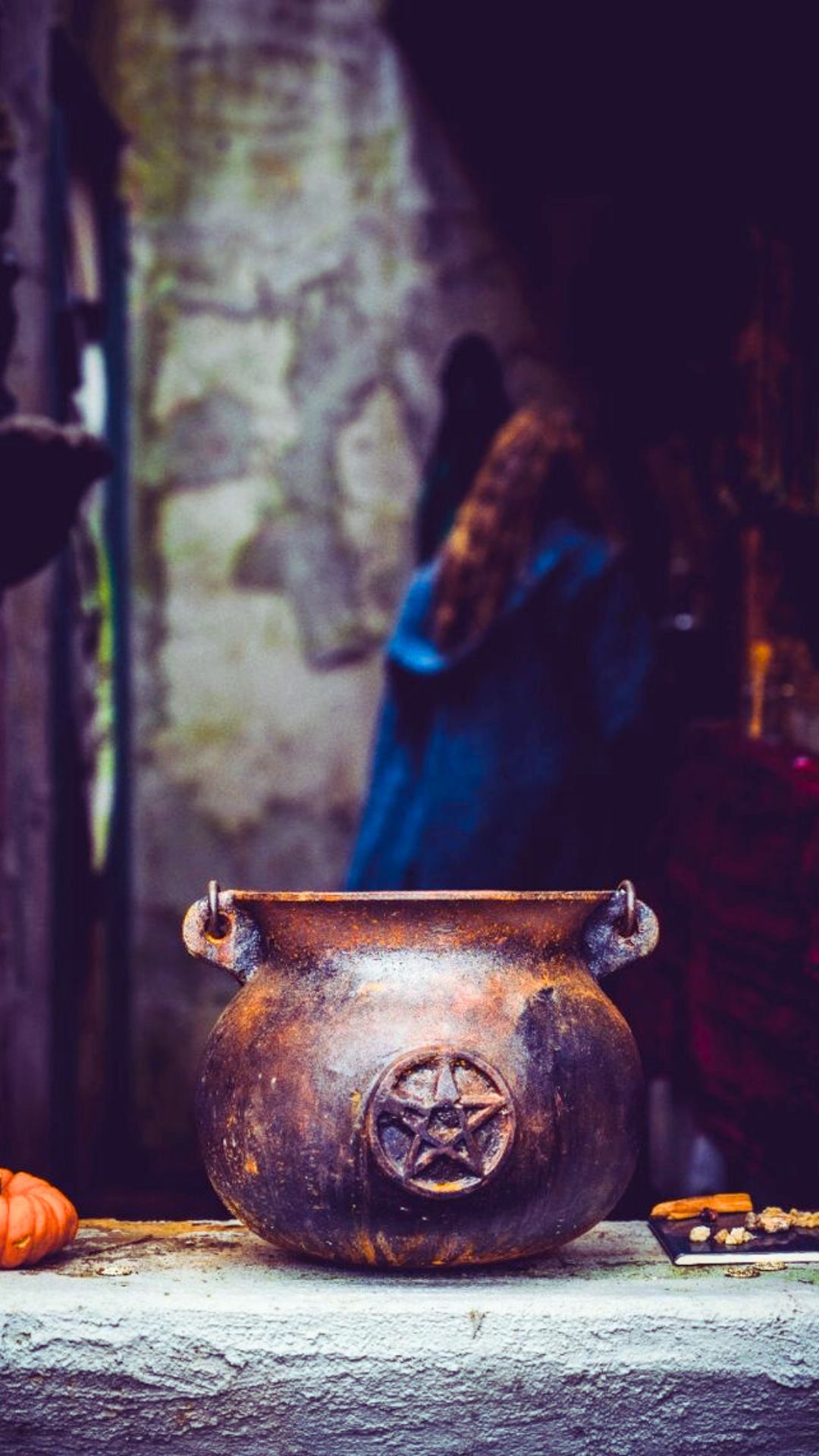 Stunning high contrast image of a cast iron witch's cauldron with a witchy woman in the background