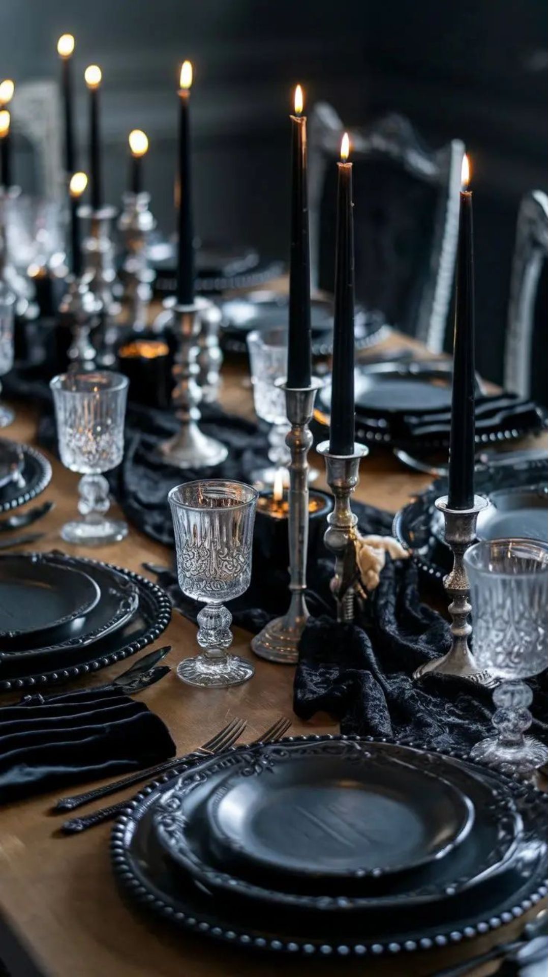 Gothic style tablescape with black plates, candles, smoked glass goblets and black table runner kitchen witch aesthetic
