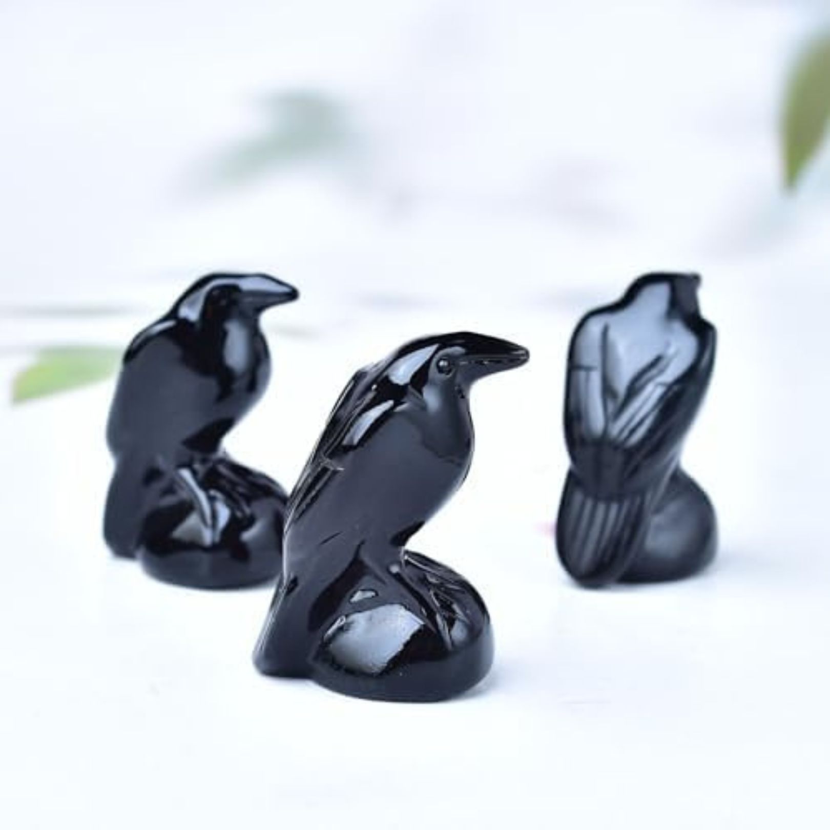 3 stunning statuettes of ravens, carved form black obsidian crystal, on a worktop serving as kitchen guardians or a hearth spirit effigy