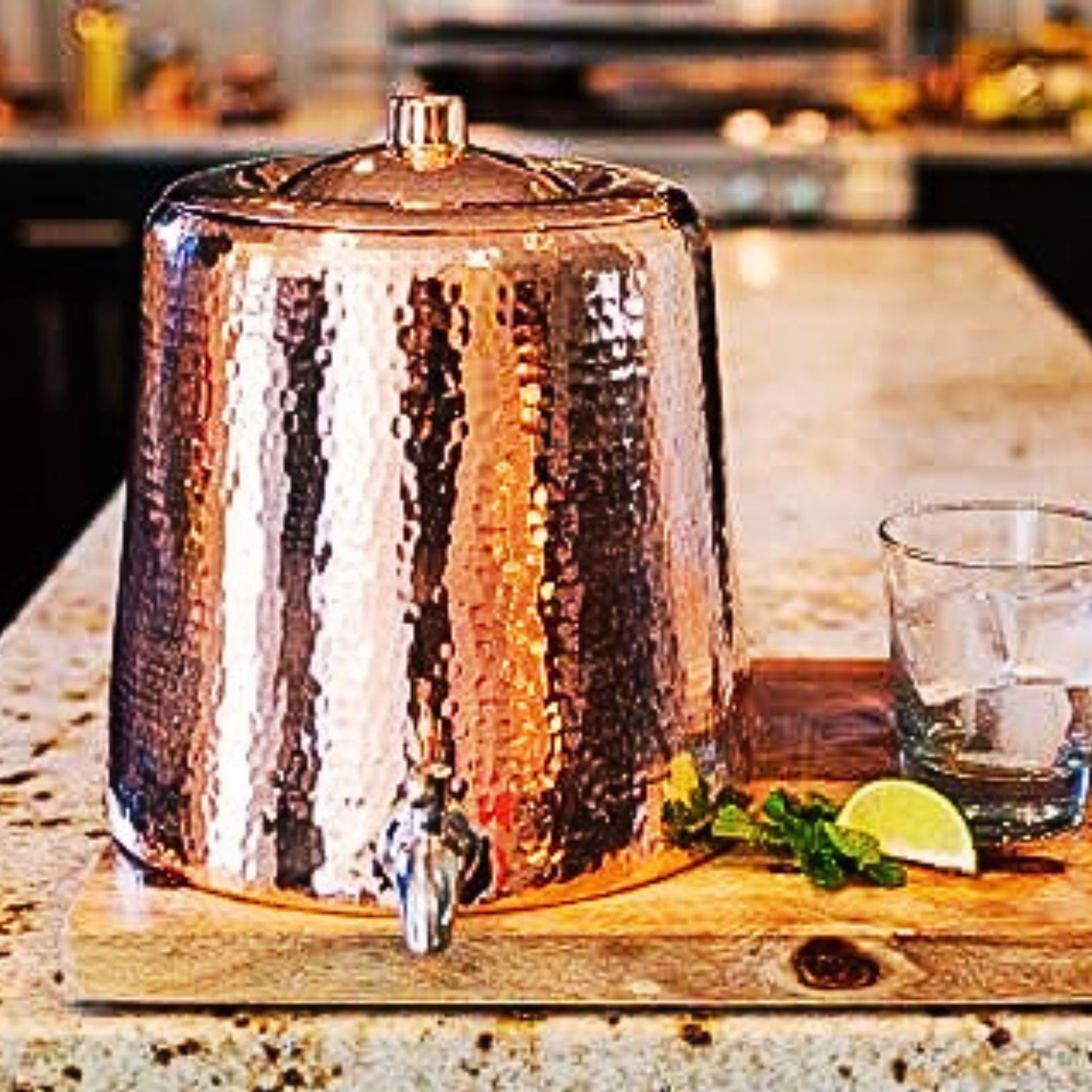 hammered copper water dispenser on a worktop in a cottage kitchen witch decor