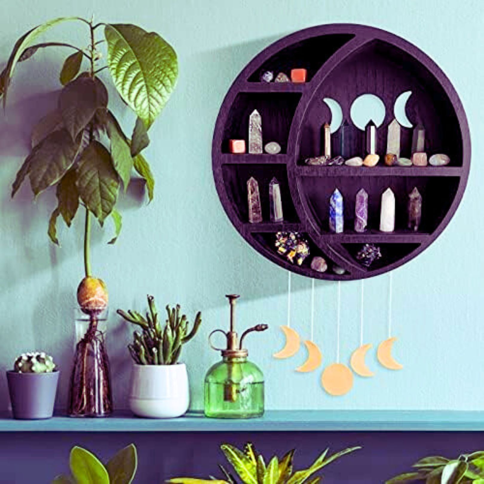 Moon shaped wooden crystal display case, painted black, in a turquoise room decor