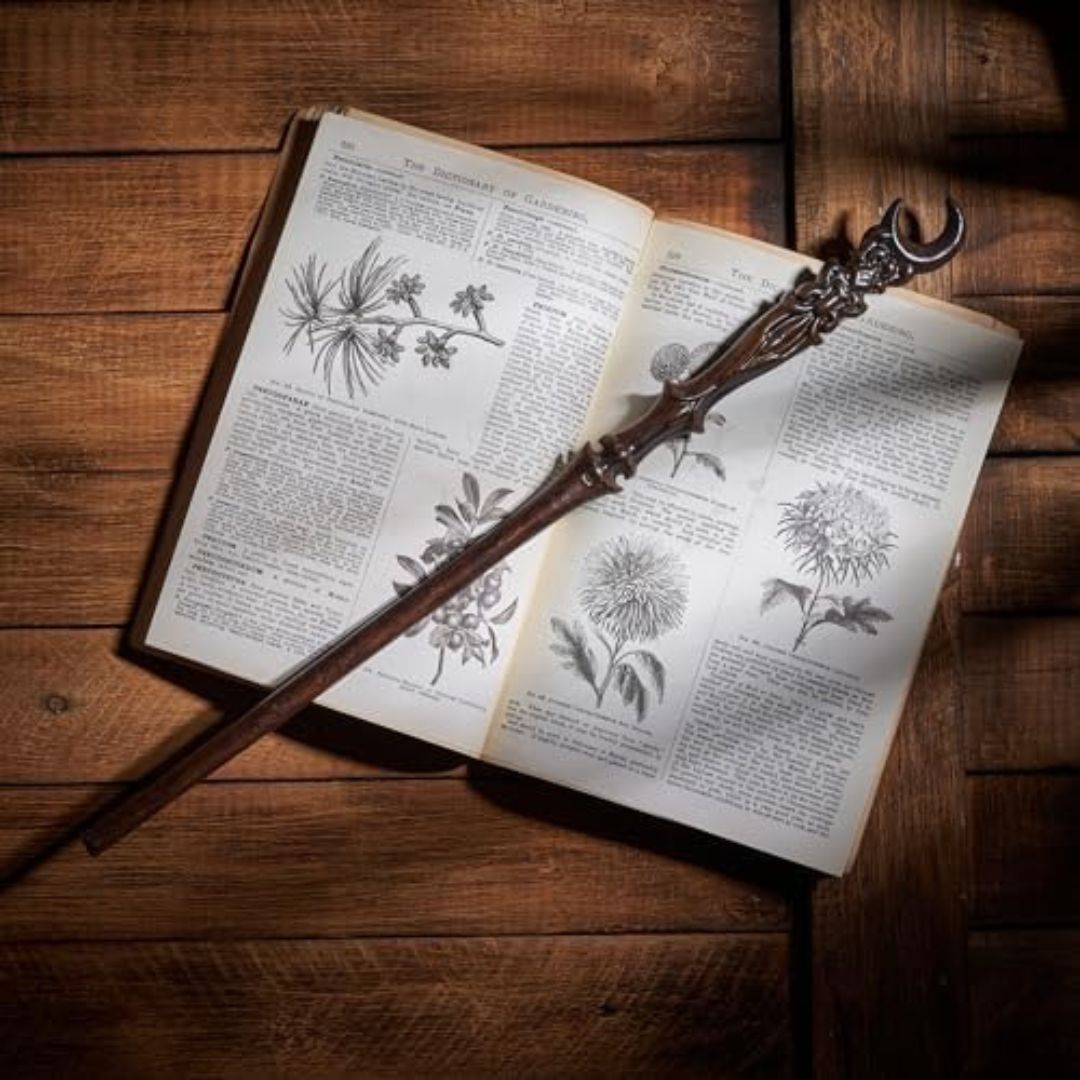 Hand-carved ornate and beautiful witch's wand, places on top of an open book